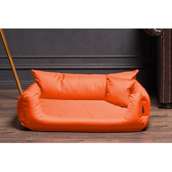 Helle orangefarbene Haustierliege mit zwei seitlichen Kissen, vor einer dunklen Wand und einem Holzboden, ideal für kleine Hunde oder Katzen.