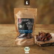 Kraftpapierbeutel von LIEBESGUT Bio‑Rind Nasenknorpel Hundesnacks mit Kuhlogo und losen Leckerlis auf einem Holzbrett