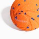Nahaufnahme eines orangefarbenen strukturierten Haustierspielzeugballs mit blauen Sprenkeln und 'Cheerble'-Logo vor weißem Hintergrund.
