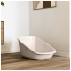 Beige Kunststoff-Haustierbadewanne auf Holzboden in einem modernen Raum mit weißen Wänden und abstrakter Wandkunst.