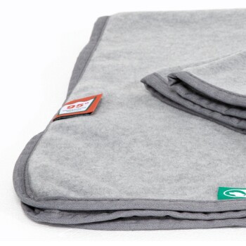 Graue Haustierdecke ordentlich gefaltet, mit Etiketten, die eine Temperatur von 95° anzeigen, und einem grünen Logo.