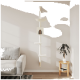 Ein moderner weißer wandmontierter Katzenbaum mit einem Versteck, Plattformen und einem Sitzplatz, neben einem grauen Sofa und einer Pflanze auf einem Tisch.