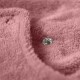 Nahaufnahme einer weichen rosa Haustierdecke mit einem silbernen Druckknopf, die ihre gemütliche Textur und sichere Befestigung hervorhebt.