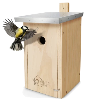 Ein Holzvogelhaus mit einem Metalldach, graviert mit "Wildlife Home", während ein Kohlmeise sich dem Eingang nähert.