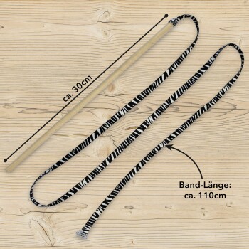 Katzenspielzeug mit einem 30 cm langen Stock und einem 110 cm langen schwarz-weißen gestreiften Band, auf einer Holzoberfläche mit beschrifteten Maßen präsentiert.