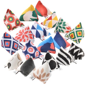 Eine Vielzahl von bunten dreieckigen Katzenspielzeugen, die in einem Raster angeordnet sind, mit auffälligen Mustern und Designs, wobei auf einigen Spielzeugen Etiketten sichtbar sind.