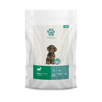 Hundefutterverpackung mit einem kleinen Hund auf der Vorderseite, beschriftet mit 'Fellicita' und dem Text 'Hirsch mit Gemüse und Hirse' sowie Symbolen für ernährungsphysiologische Vorteile.
