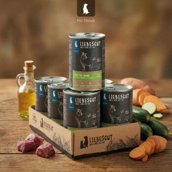 Liebesgut Hundefutterdosen in einem Tray mit Aufschrift 'Weil Liebe gut tut', mit rohem Fleisch, Zucchini- und Süßkartoffelscheiben sowie einer Ölflasche.