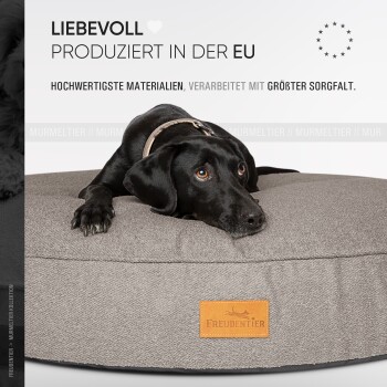 Ein graues Haustierbett mit einem Lederetikett mit der Aufschrift "Freudentier", mit Informationen über Oeko-Tex-Zertifizierung und Sicherheitsstandards.