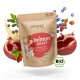 Curapet Immun Kraft Superfood-Pulver für Hunde, mit einem beigen Beutel mit rotem Etikett, umgeben von Granatapfel, Beeren und Kräutern.