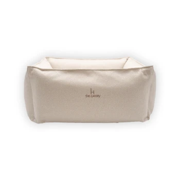 Ein beiges Haustierbett in quadratischer Form, mit dem auf der Vorderseite gestickten Text "THE CATERY."