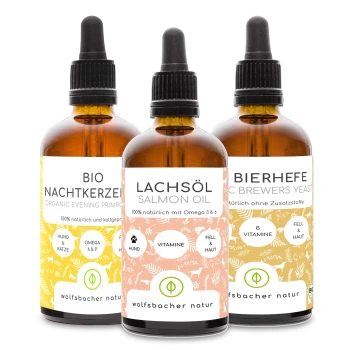 Drei Flaschen mit Haustierergänzungen: Bio-Nachtkerzenöl, Lachsöl und Bierhefe, jede mit detaillierten Etiketten.