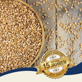 Eine Holzschüssel, gefüllt mit Hafer auf einer Holzoberfläche, mit verstreuten Haferflocken darum herum. Ein Abzeichen liest "Beste Qualität" und "15 Jahre" auf Deutsch.