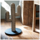 Ein Seil-Kaktus-Kratzbaum auf einer schwarzen runden Basis, positioniert auf Holzboden neben einem rustikalen Holztisch.