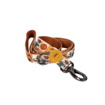 Orange-lined pet leash with cowboy dog pattern, metal clasp and yellow round tag; ribbon shows small cursive text.