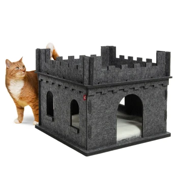 Filz Katzenburg Felty Fort anthrazit Eine verspielte orangefarbene Katze steht neben einem grauen Filz-Katzenhaus in Form einer Burg mit gewölbten Eingängen und einem weichen Innenraum.