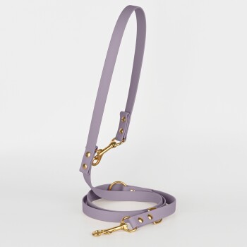 Eine lavendelfarbene Hundeleine mit goldenen Beschlägen, mit einem glatten Design und verstellbaren Clips, vor einem weißen Hintergrund präsentiert.