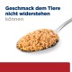 Löffel mit stückigem Nassfutter und deutschem Text „Geschmack dem Tiere nicht widerstehen können“ auf weißem Hintergrund.