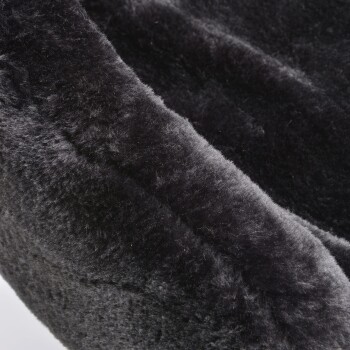 Nahaufnahme eines weichen, plüschigen schwarzen Haustierbettes mit abgerundetem Rand, das seine gemütliche Textur und einladende Erscheinung zeigt.