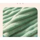 Nahaufnahme einer weichen, strukturierten grünen Haustierdecke mit Rillen, die ihr plüschiges Material und einladendes Aussehen zeigt.