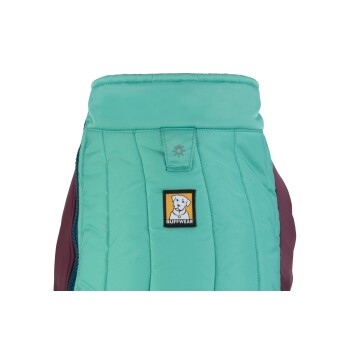 Nahaufnahme einer türkisfarbenen und kastanienbraunen Hundejacke mit dem Ruffwear-Logo, die ihr gestepptes Design und einen Druckknopfverschluss oben zeigt.