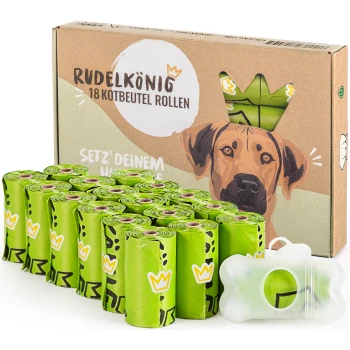 Grüne kompostierbare Kotbeutel in Rollen, verpackt in einer Pappschachtel mit der Aufschrift "RudelKönig POOP BAGS", mit einem knochenförmigen Spender.