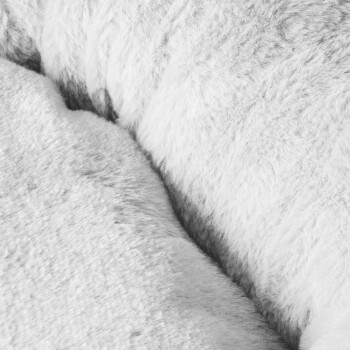 Nahaufnahme von weichem, flauschigem Haustierbettzeug in Weiß- und Grautönen, das eine gemütliche Textur zeigt, die ideal für Haustiere ist.