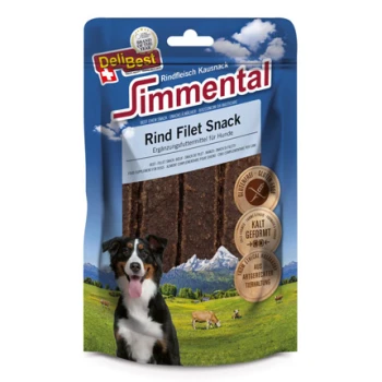 Eine Hundeleckerlipackung mit "Simmental Rind Filet Snack" für Hunde, mit einem schwarz-weißen Hund vor einer Berglandschaft.
