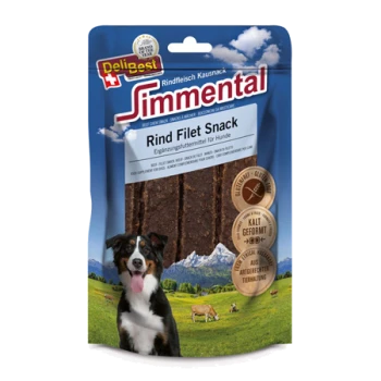 Eine Hundeleckerlipackung mit "Simmental Rind Filet Snack" für Hunde, mit einem schwarz-weißen Hund vor einer Berglandschaft.