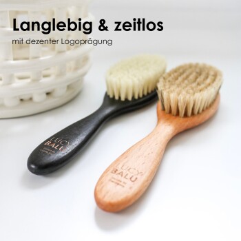 Zwei Haustierpflegebürsten: eine schwarze mit weichen Borsten, eine aus Holz mit festen Borsten, auf einer weißen Oberfläche. Text: "Langlebig & zeitlos."