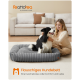 Schwarz-weißer Hund sitzt auf einem grauen Plüsch-Hundebett, eine Frau steht daneben, der Text lautet „Flauschiges Hundebett“ und „Eine Kuscheloase voller Komfort und Liebe“.
