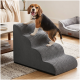 Beagle-Welpe steht auf grauen, gerippten Haustiertreppen im Wohnzimmer; weiches Hundebett und Couchtisch sichtbar.