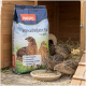 Drei Wachteln neben einem Haufen Futterpellets und einem Sack PANTO Legewachtelfutter Plus Vogelfutter.