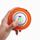 Hand hält ein orangefarbenes Stoff-Haustierspielzeug mit weißem elektronischem Zentrum und drei leuchtend grünen, pfotenförmigen LEDs.