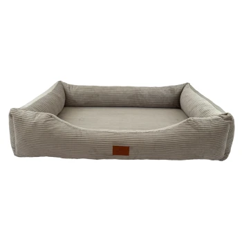 Ein plüschiges, beiges Haustierbett mit erhöhten Seiten und einem weichen Inneren, mit einem kleinen Lederetikett, das 'PETLIVING' liest.