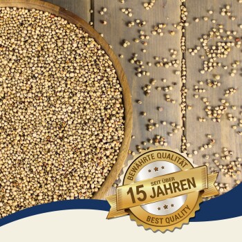 Eine Holzschale mit hellen Samen auf einer Holzoberfläche, mit verstreuten Samen und einem Abzeichen mit "15 Jahre" und "Beste Qualität."