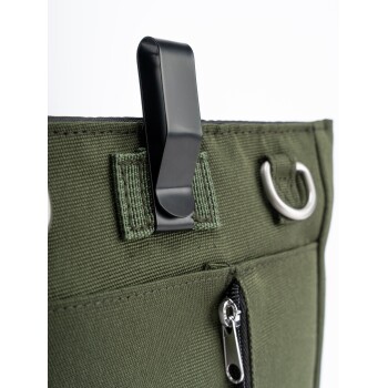 Nahaufnahme einer grünen Tragetasche für Haustiere mit einem schwarzen Clip, Reißverschluss und Metallring, die strapazierfähigen Stoff und Designdetails zeigt.