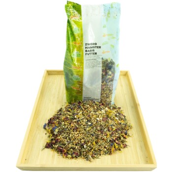 Ein Sack 'Zwerg Hamster Basis Futter' steht aufrecht neben einem Haufen buntem, gemischtem Hamsterfutter auf einem Holztablett.