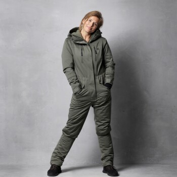 Ein Modell steht selbstbewusst in einem stilvollen olivgrünen Overall mit Kapuze, der mit Reißverschlusstaschen und einer taillierten Taille ausgestattet ist, vor einem grauen Hintergrund.