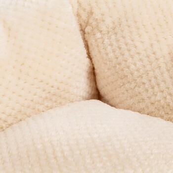 Nahaufnahme eines weichen, cremefarbenen Haustierbettes mit einer plüschigen, strukturierten Oberfläche, ideal für den Komfort von Haustieren.