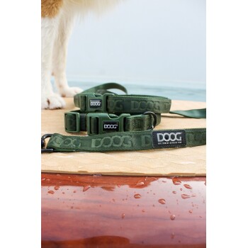 Eine grüne Hundeleine mit dem Markennamen "DOOG", die prominent auf einer strukturierten Oberfläche mit Wassertropfen liegt.
