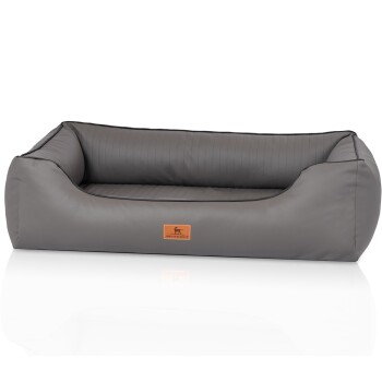 Graues Hundebett mit einem plüschigen Innenraum und einem braunen Lederetikett mit einer Hundesilhouette und dem Markennamen "KNUFFELWUFFS."