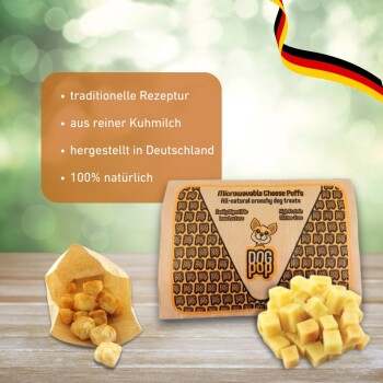 Ein Cavalier King Charles Spaniel auf einem Holzboden, der Wildfang® weiche Käsesnacks kaut – getreidefrei, zuckerfrei und allergiefreundlich.