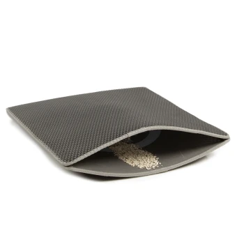 Eine graue Futtermatte für Haustiere mit einer strukturierten Oberfläche, teilweise geöffnet, um verstreutes Haustierfutter im Inneren zu zeigen.