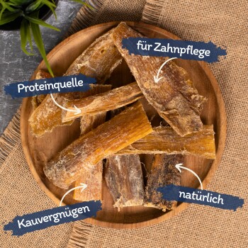 Ein Holzbrett mit Hundekauartikeln, die auf Deutsch beschriftet sind: "Proteinquelle," "für Zahnpflege," "Kauvergnügen," und "natürlich."