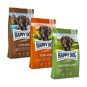 Drei Beutel Happy Dog Sensible Hundefutter: Kanada (Lachs, Kaninchen, Lamm), Toscana (Ente, Lachs) und Neuseeland (Lamm), jeweils für erwachsene Hunde gekennzeichnet.