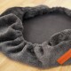 Gemütliches graues Haustierbett mit einem weichen, plüschigen Rand und einem dunklen Zentrum, perfekt für kleine Tiere zum Einkuscheln.