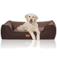 Ein Golden Retriever ruht sich bequem auf einem plüschigen, braunen Hundebett mit einem Holzschild, das ein Logo zeigt, und präsentiert eine gemütliche Haustierumgebung.
