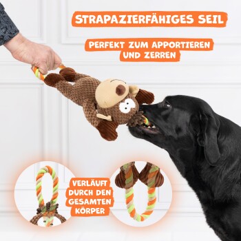 Ein schwarzer Hund zieht verspielt an einem moosförmigen Spielzeug an einem bunten Seil. Text: "Strapazierfähiges Seil" und "Perfekt zum Apportieren und Zerren."