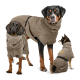 Drei Hunde tragen passende braune Fleece-Hundemäntel, einer mit sichtbarem gelbem Kronenlogo auf dem Rücken.